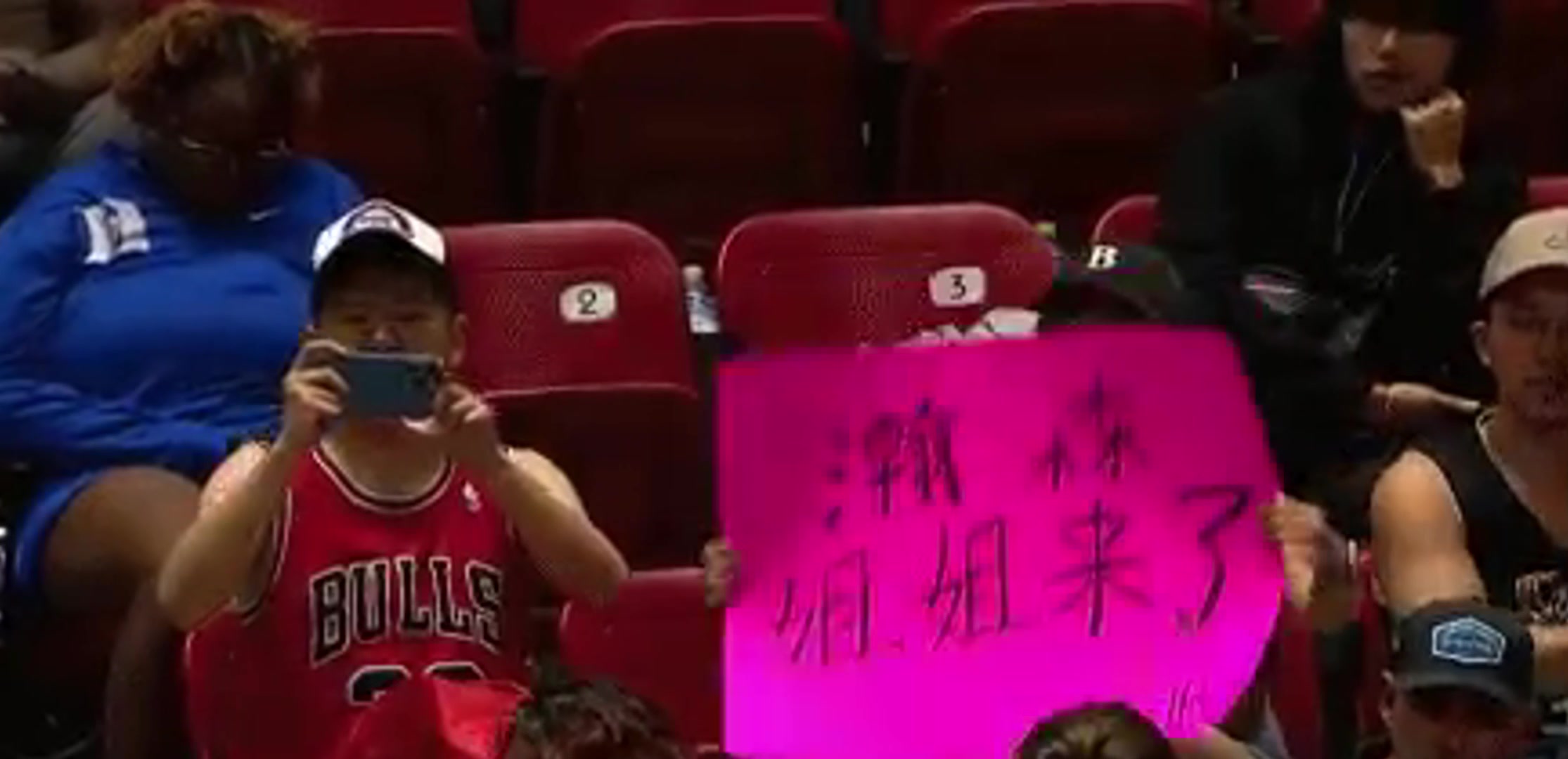 一中国女球迷在观众席举牌支持杨瀚森：瀚森，姐姐来了！